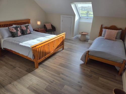 a bedroom with two beds and a window at Sheehan's in Bealaclugga