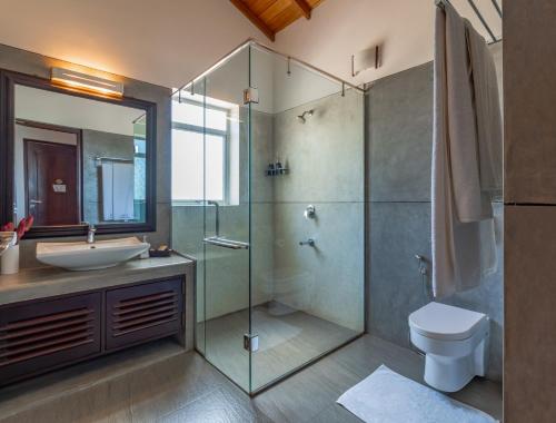 a bathroom with a glass shower and a sink at Tartaruga Beach Unawatuna in Unawatuna