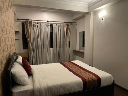 a bedroom with a bed and a window at Mughal Empire Hotel Pvt ltd in Pātan