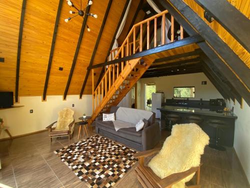a living room with a staircase and a piano at Chalés Sol da Serra in Rio Rufino