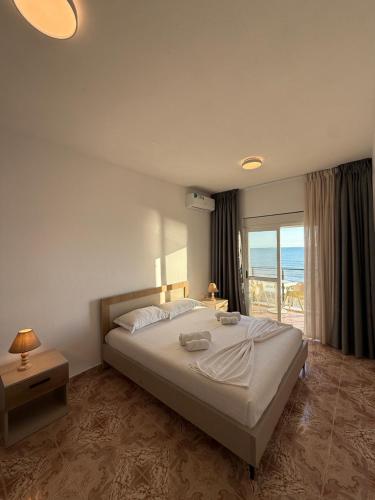 a bedroom with a bed with a view of the ocean at Heming-way Hotel in Durrës