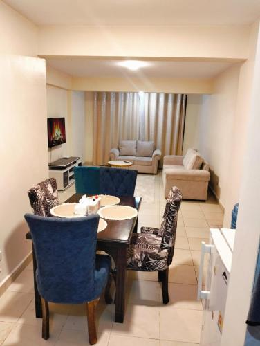 a living room with a table and chairs and a couch at jjsuites in Athi River