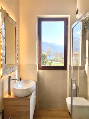 a bathroom with a sink and a mirror and a window at Casa Cinzia in Gravedona