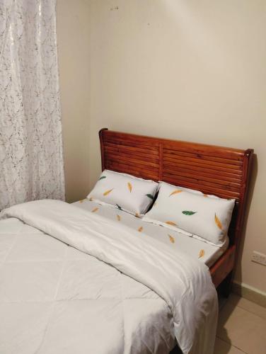 a bedroom with a bed with white sheets and pillows at jjsuites in Athi River