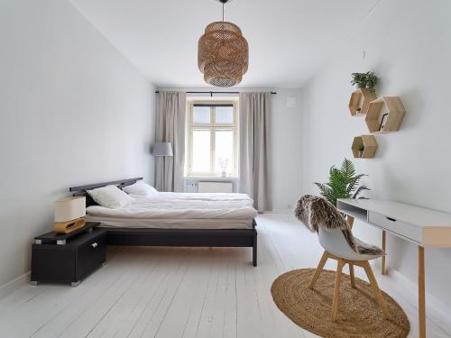a white bedroom with a bed and a desk at Beautiful and Spacious Studio in Helsinki in Helsinki