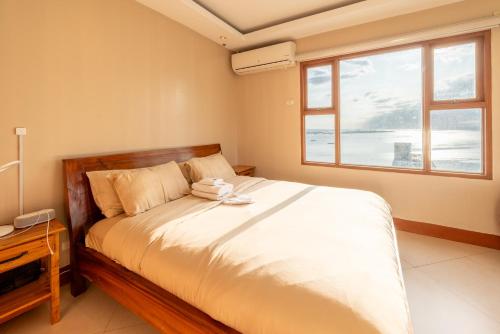 a bedroom with a bed and a window at STAYLUXIA MANILABAYVIEW - FEATURING 1 - 5 BEDROOM SUITES WITH BALCONY POOL BAYVIEWS NETFLIX - Housekeeping Available- in Manila