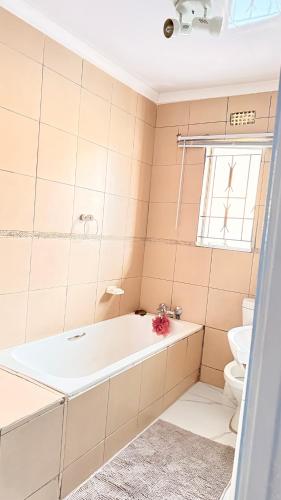 a bathroom with a tub and a toilet at 33OnPangolin B&B in Nelspruit