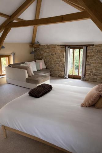 a large white bed in a room with windows at Woolladon Hall in Meeth