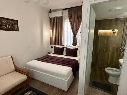 a small bedroom with a bed and a shower at Manga guesthouse in Gjirokastër