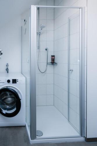 a shower in a bathroom with a washing machine at Seethal in Laufen