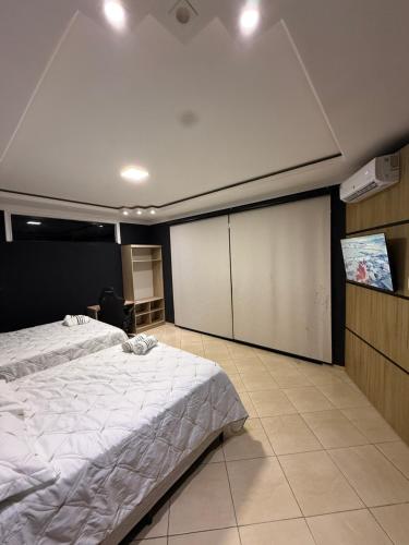 a bedroom with two beds and a projection screen at Casa Bragança suíte in Bragança