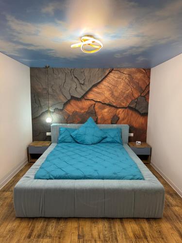 a bedroom with a large bed with a stone wall at Woodxury in Petrila