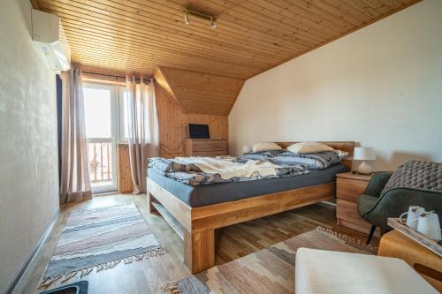 a bedroom with a bed and a large window at Pension Harmony in Bešeňová