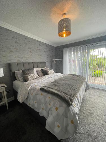 a bedroom with a large bed and a window at Kirkhill Cottage B&B in Crossmichael