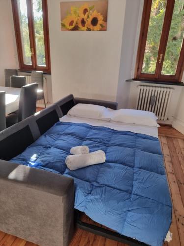 a large blue bed with two towels on it at sunflower apartment in Domaso
