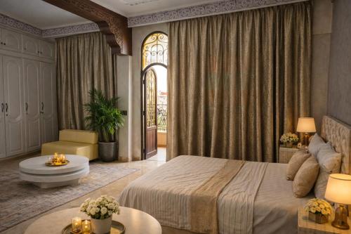 a bedroom with a bed and a table and a window at Appartement Spacieux 2 Chambres avec vue sur le jardin - Taroudant in Taroudant