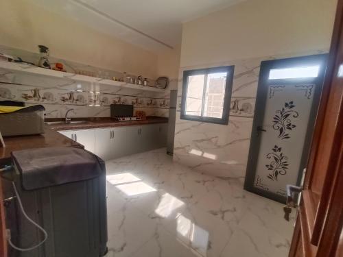 a kitchen with white marble floors and a window at شقق تاج الداخلة in Dakhla