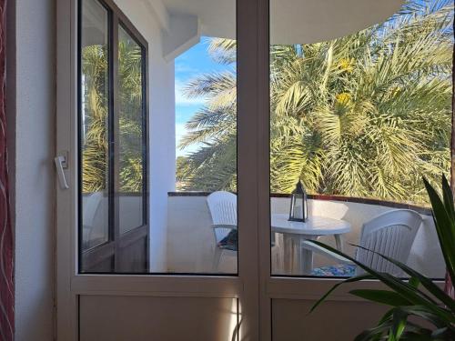 a glass door with a table and chairs on a balcony at Appartement El Palmar Denia in Denia