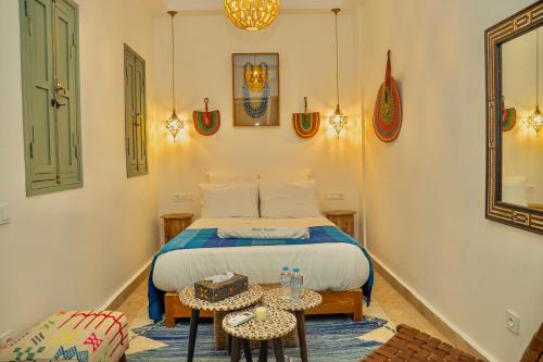 a bedroom with a bed and two tables in it at Riad Yamat privatisé au cœur de la Médina 3 chambres 10 min Jemaa el-Fna in Marrakesh