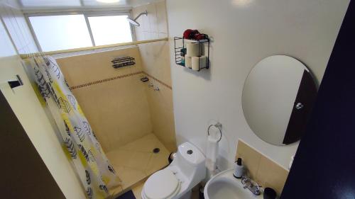a bathroom with a toilet and a sink and a mirror at Depa Balcones cerca Estadio GNP, Palacio de los Deportes, Autódromo HR y Aeropuerto CDMX in Mexico City