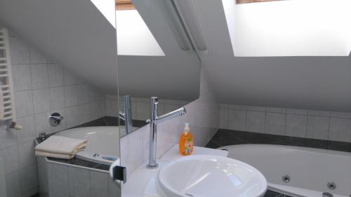 a bathroom with a sink and a bath tub at Pension Elisabeth - Rooms & Apartments in Salzburg