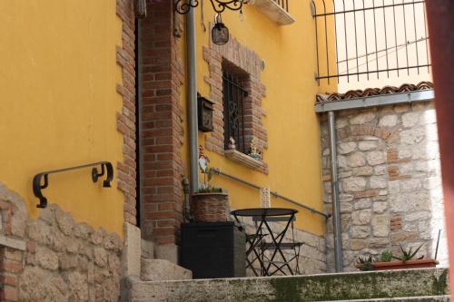 a yellow building with a table and a window at Dimora San Mercurio 100 in Campobasso