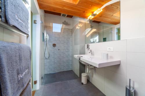 a bathroom with a sink and a mirror at Der Bognerhof - Ferienwohnungen mit beheiztem Salzwasserpool in Riffian bei Meran in Rifiano