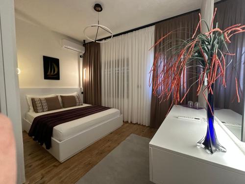 a bedroom with a bed and a vase with a plant at Manga guesthouse in Gjirokastër