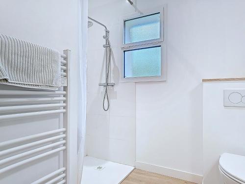 a white bathroom with a shower and a toilet at Appartement Le Porto in Cholet