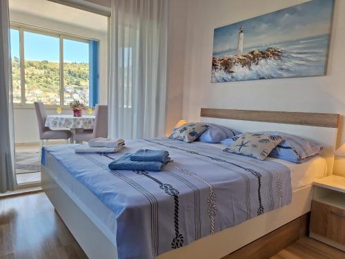 a bedroom with a large bed with blue sheets at Apartments Villa Sirena in Dubrovnik