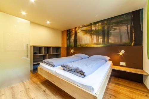 a bedroom with a bed with a painting on the wall at Der Bognerhof - Ferienwohnungen mit beheiztem Salzwasserpool in Riffian bei Meran in Rifiano