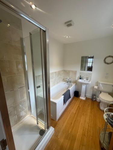 a bathroom with a shower and a tub and a toilet at Braemore Walled Garden in Garve