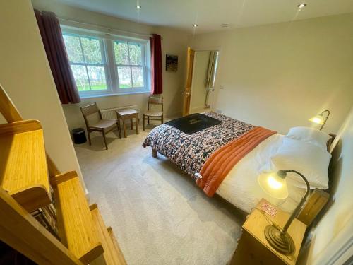 a bedroom with a bed and a table and chairs at Braemore Walled Garden in Garve