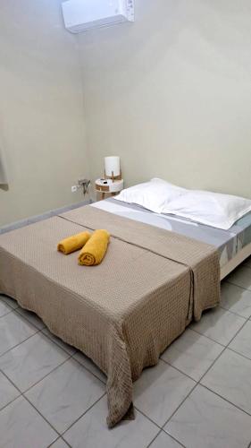 a bed with two yellow pillows on top of it at VILLA Ti-COULANGE, Verdoyante in Rivière-Pilote