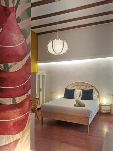two images of a bedroom with a bed and a painting at Bellver bedrooms in Xàtiva