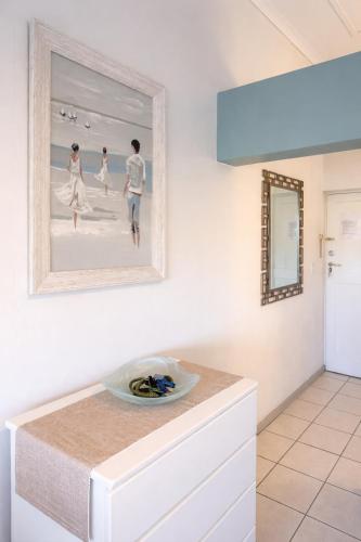 a painting of three people walking on the beach on a wall at Goose Valley Golf Estate D7 in Plettenberg Bay