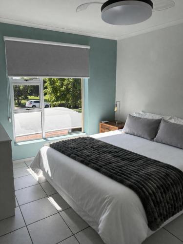a bedroom with a large bed and a large window at Goose Valley Golf Estate D7 in Plettenberg Bay