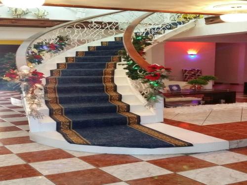 a spiral staircase in a lobby with christmas decorations at Hotel Rey in Concepción de La Vega