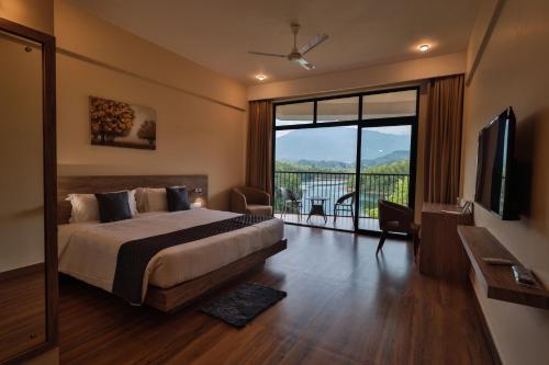 a hotel room with a bed and a large window at Serene Aqua Hills in Kozhikode