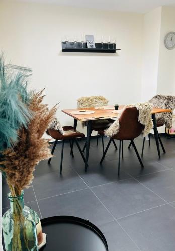 a dining room with a table and chairs and a vase at FeWo Wanderlustig in Wolfstein