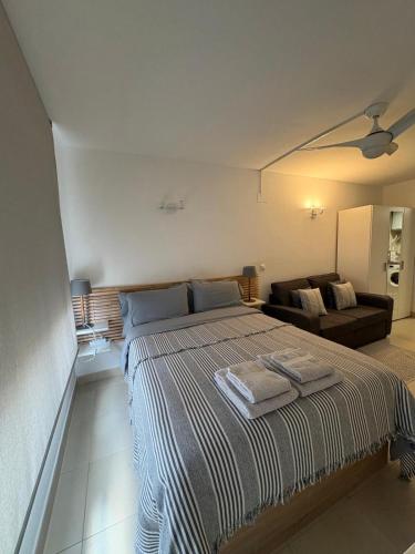 a bedroom with a large bed and a couch at Luminoso Estudio en la playa de el Campello in El Campello