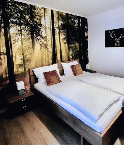 a large bed in a bedroom with a large window at Pension Waldschloß in Holzminden