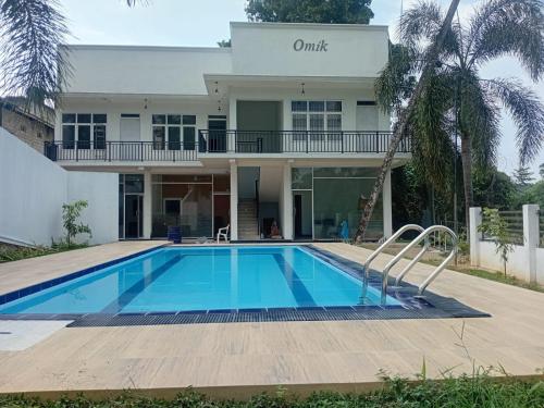 a house with a swimming pool in front of it at Omik Residence in Dinapamunuwa