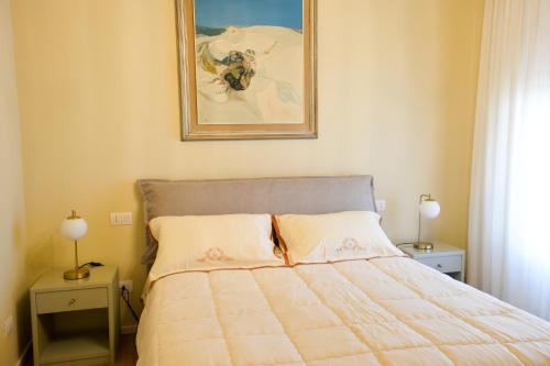 a bedroom with a bed and a painting on the wall at Villa alle Mura in Lucca