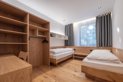 a room with two beds and a window at Plan de Corones Apartment in San Sigismondo