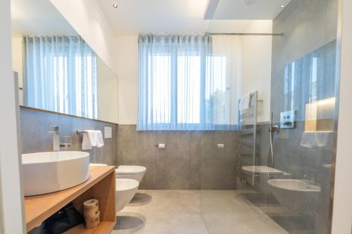 a bathroom with a sink and a toilet and a shower at Plan de Corones Apartment in San Sigismondo