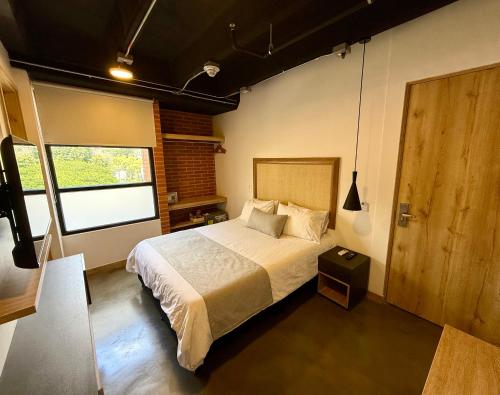 a bedroom with a large bed and a window at Akela Park Hotel in Medellín