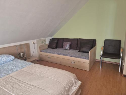 a bedroom with a bed and a couch and a chair at Spacious Apartment Panemune in Kaunas
