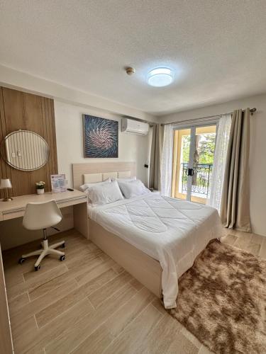a bedroom with a bed and a desk and a window at CJ Premier Stays at Amalfi Oasis Near SM Seaside Mall & Nustar Casino Hotel, Cebu City in Cebu City