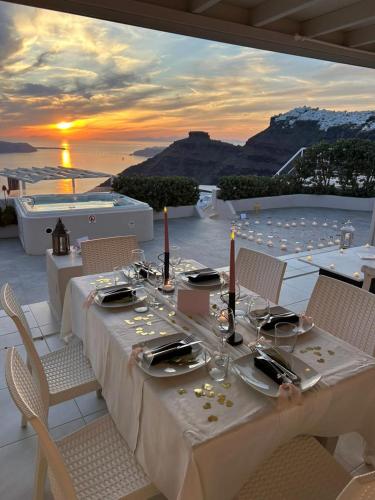 a dinner table with a view of the ocean at Sunset View Villa Santorini - with Outdoor Jacuzzi in Firostefani